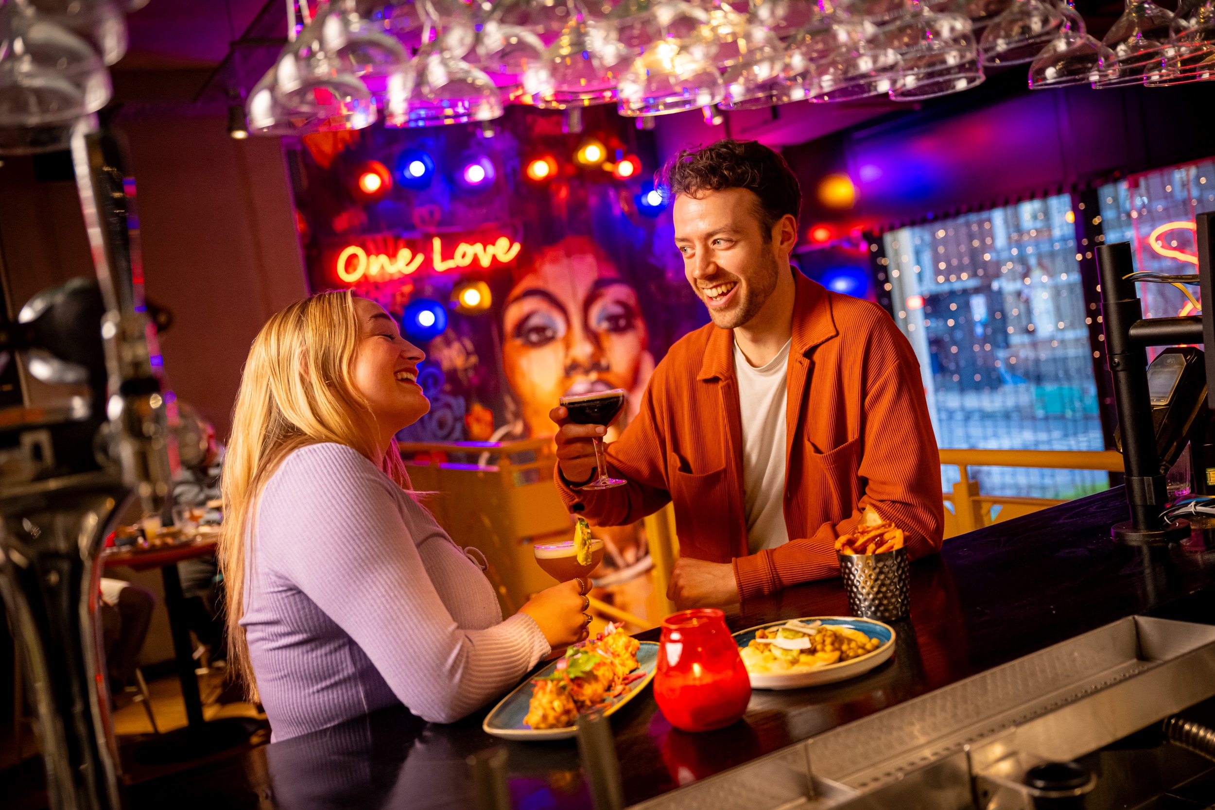 Couple sharing drinks and small plates at the bar