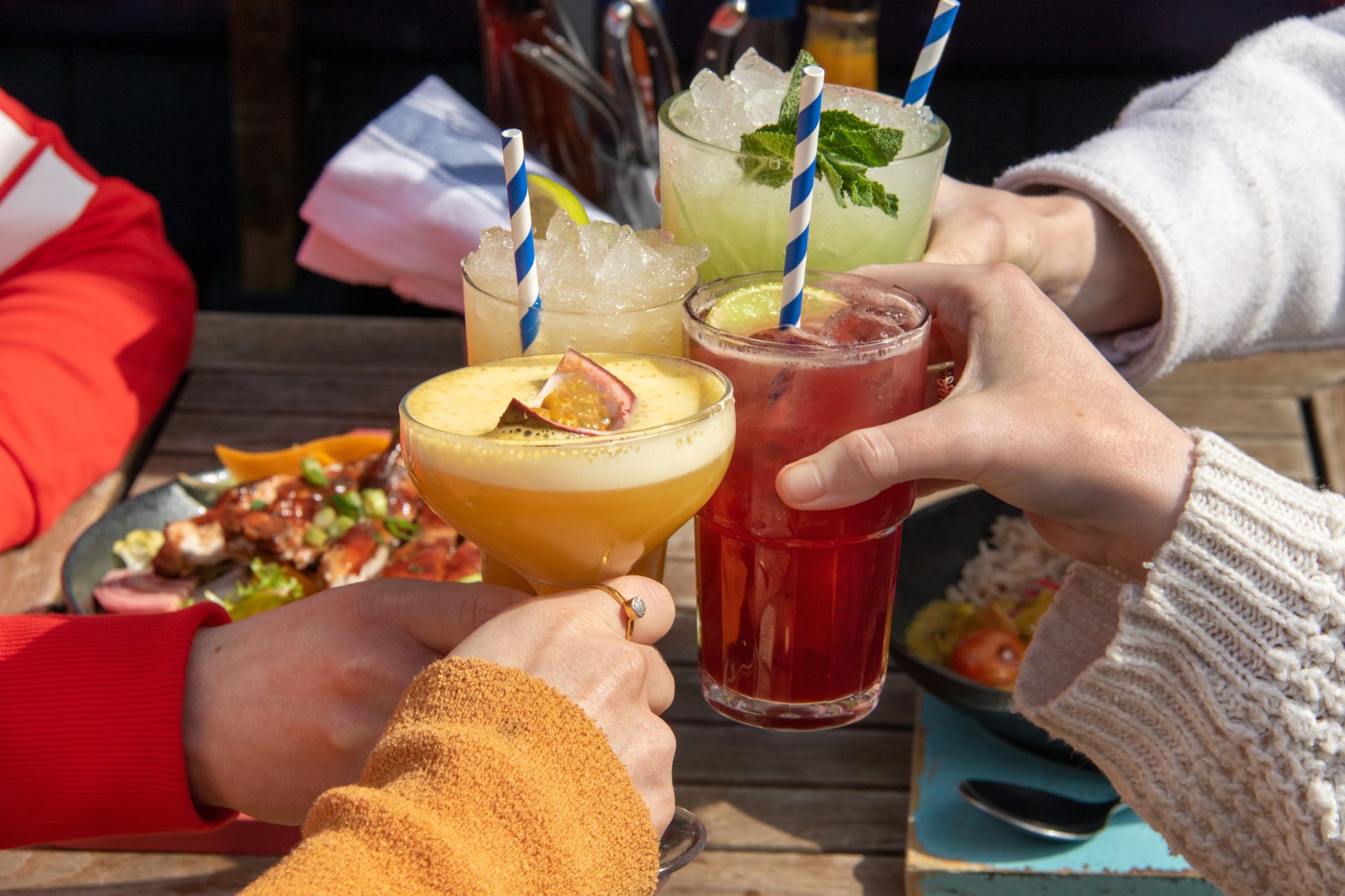 Cheersing Cocktails Outside in Sunshine