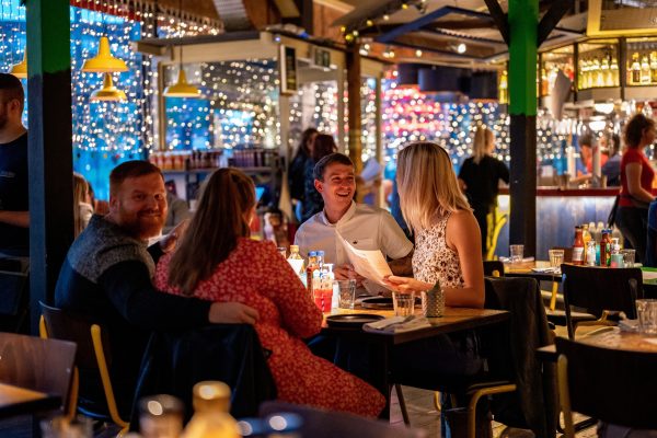 Guests Laughing and looking at the menu with fairy lights in the background
